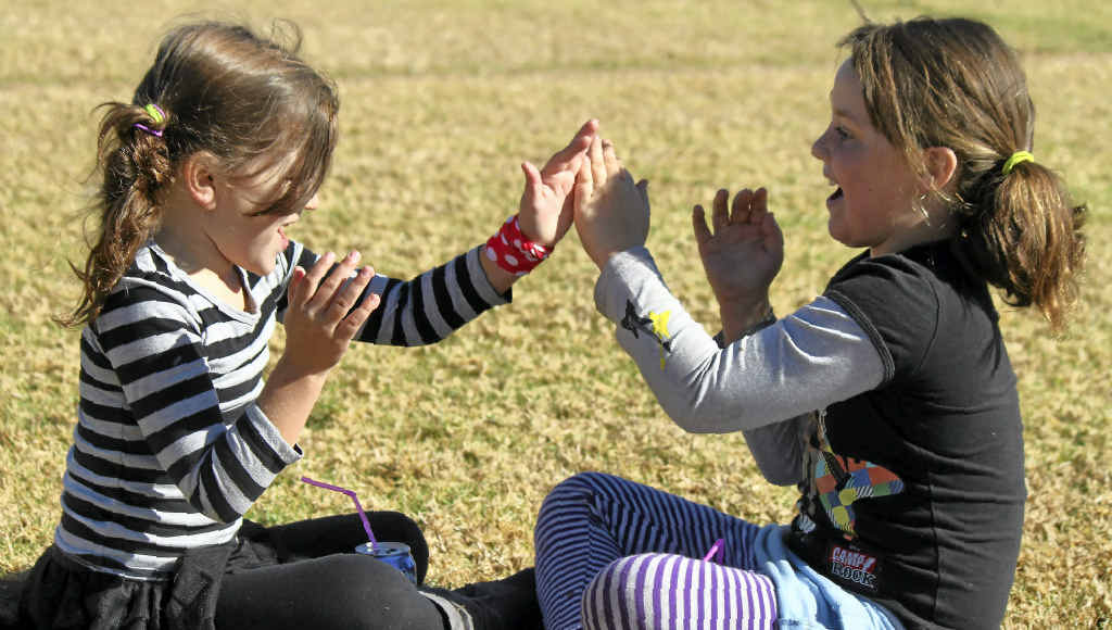Ella Talbot and Nadine Sampson play clapping games in the sunshine at the weekend.